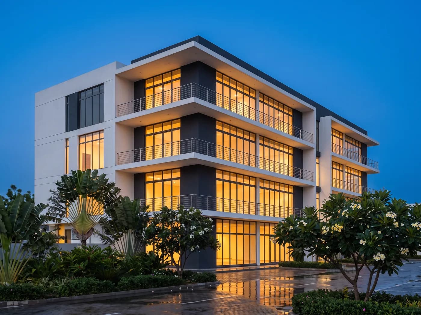 A modern multi-storey commercial building lit from within at dusk